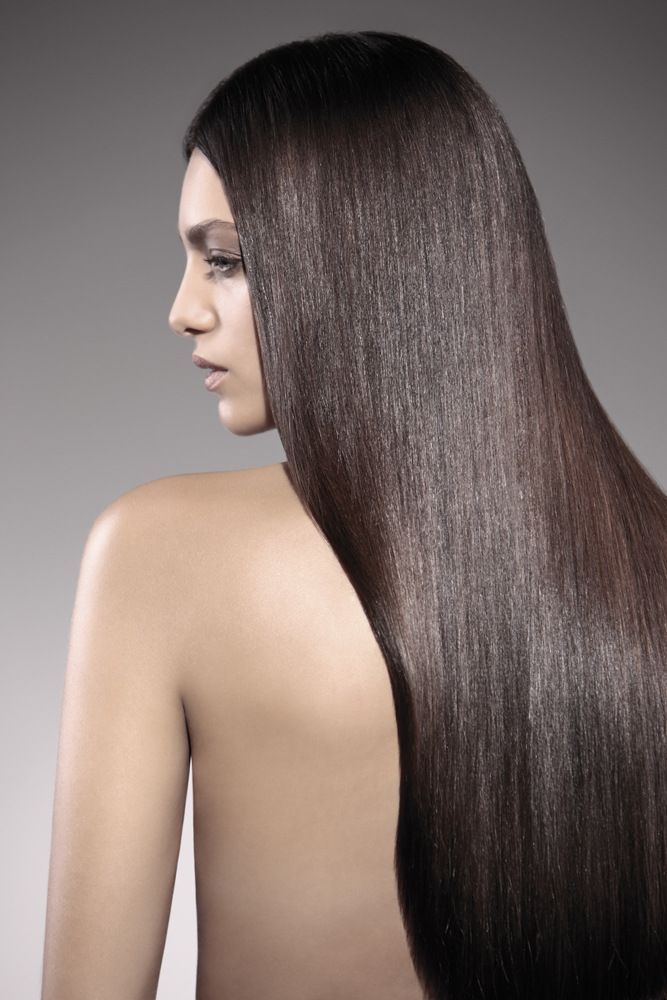 Eine Frau mit sehr langen Haaren steht mit dem Rücken zur Kamera.