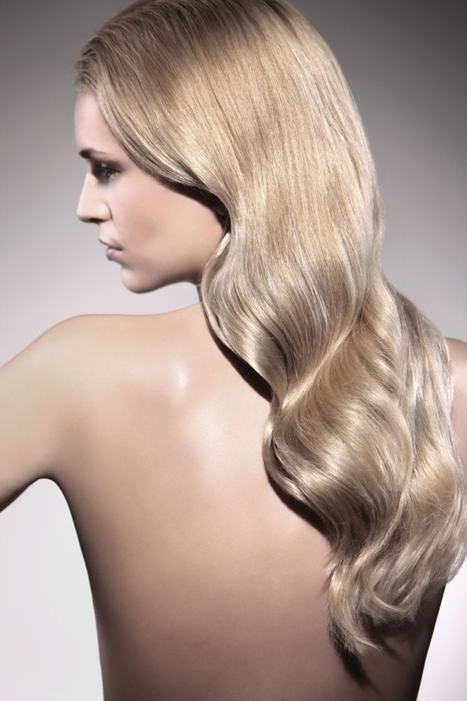 Eine Frau mit langen blonden Haaren steht mit dem Rücken zur Kamera.