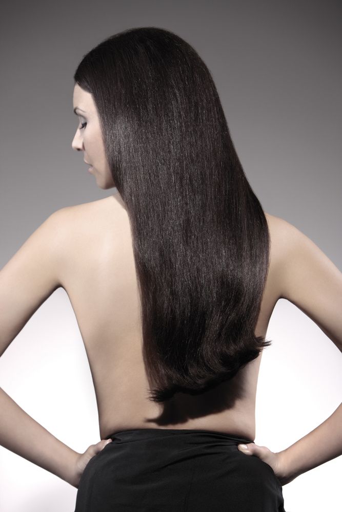 Eine Frau mit langen Haaren steht mit den Händen auf den Hüften