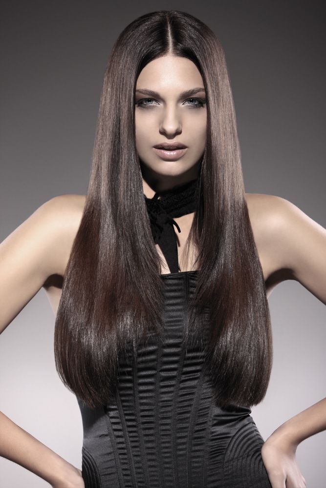 Eine Frau mit langen braunen Haaren trägt ein schwarzes Kleid