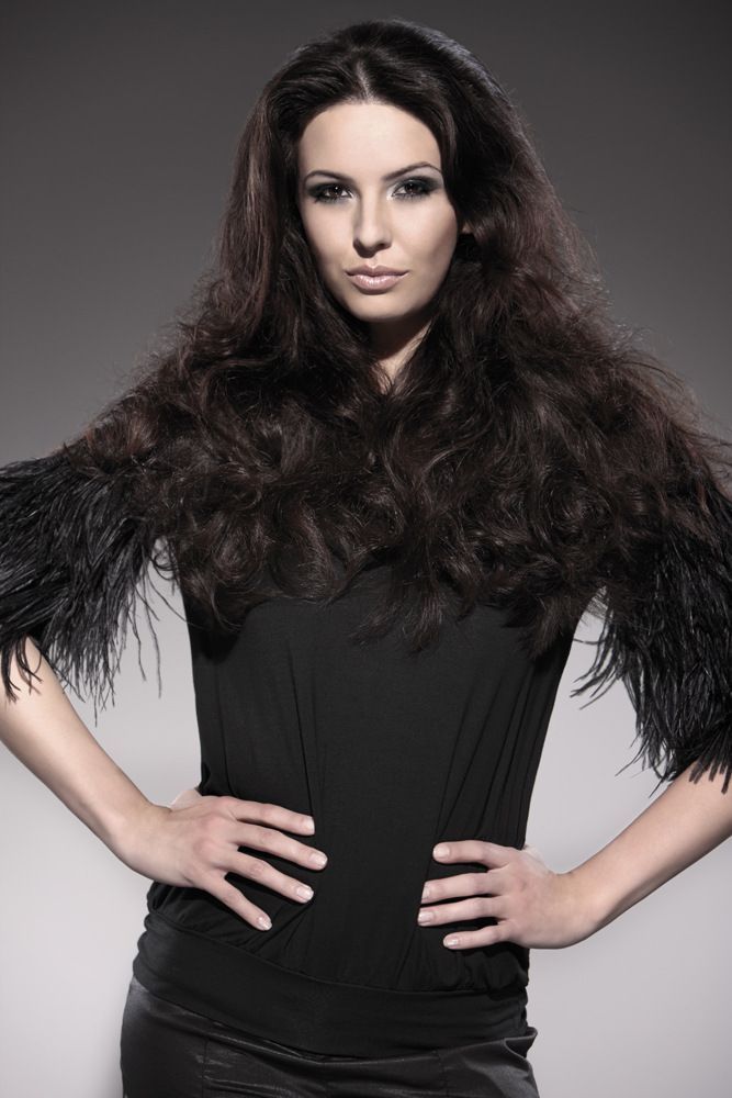 Die Frau trägt ein schwarzes Oberteil mit Federärmeln.