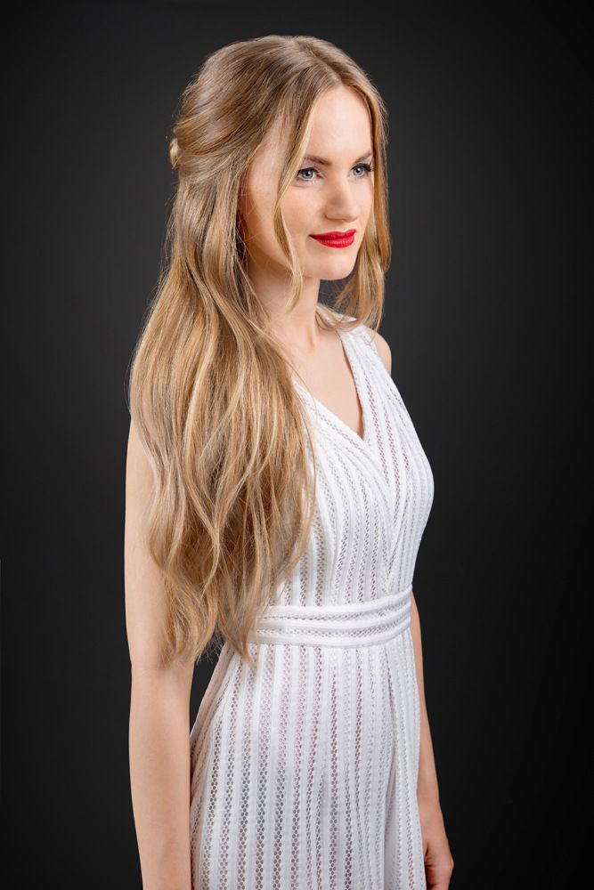 Die Frau trägt ein weißes Kleid und roten Lippenstift.