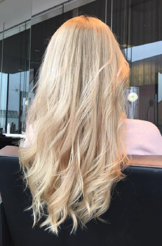 Eine Frau mit langen blonden Haaren sitzt auf einem Stuhl.