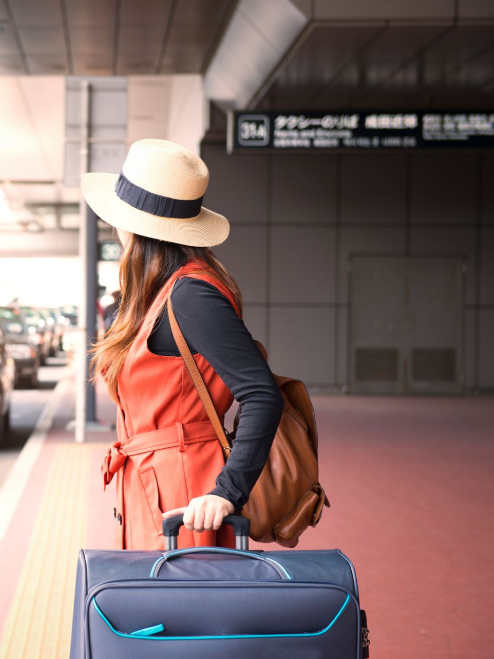 Femme attendant un taxi avec sa valise