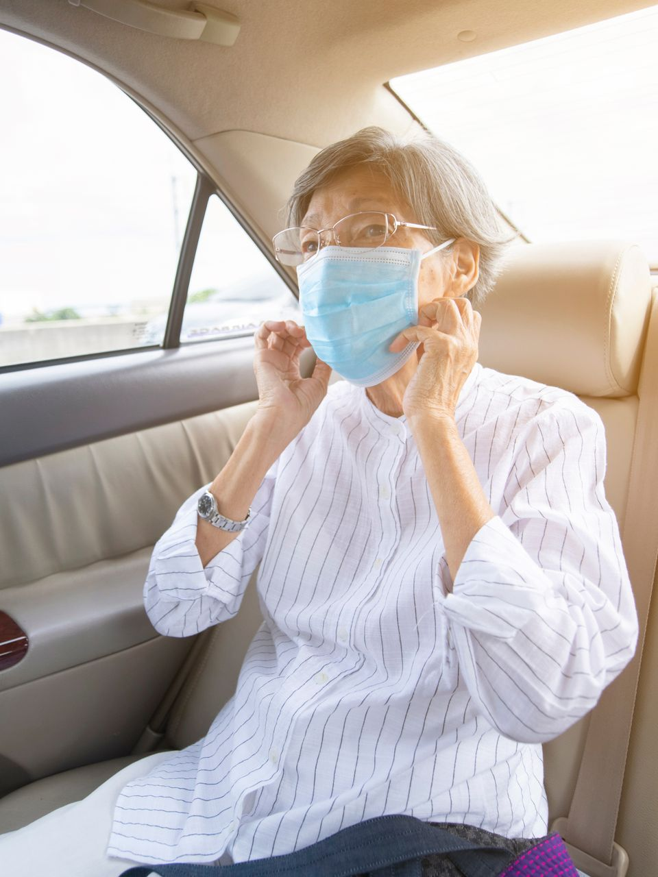 Vieille femme avec un masque dans un taxi