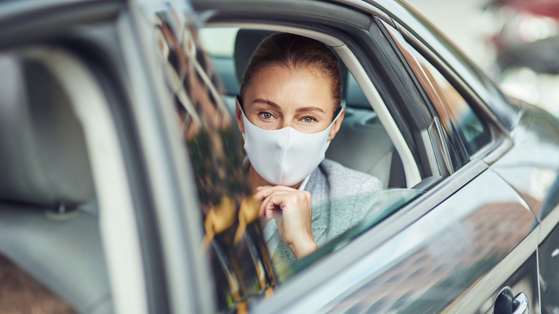 Femme avec un masque dans un taxi