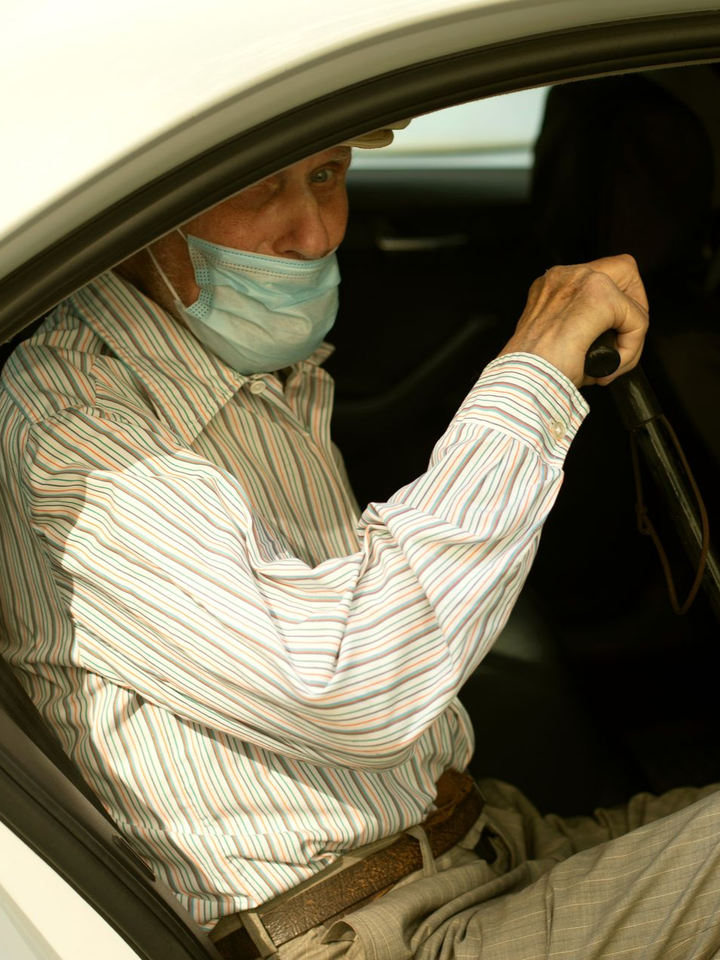 Vieux monsieur avec une canne dans un taxi