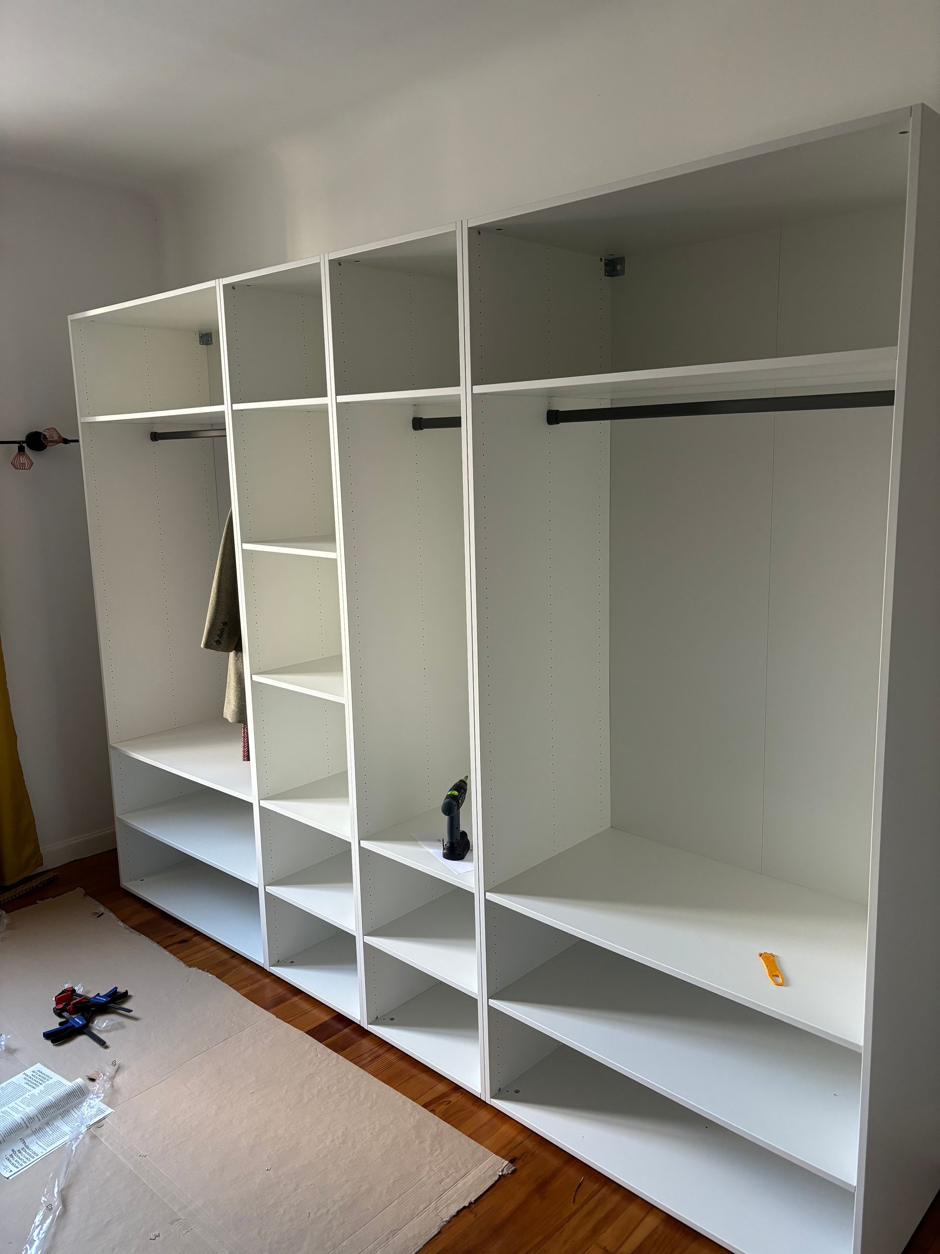 Étagères et tringles à vêtements blanches encastrées dans une chambre en construction.