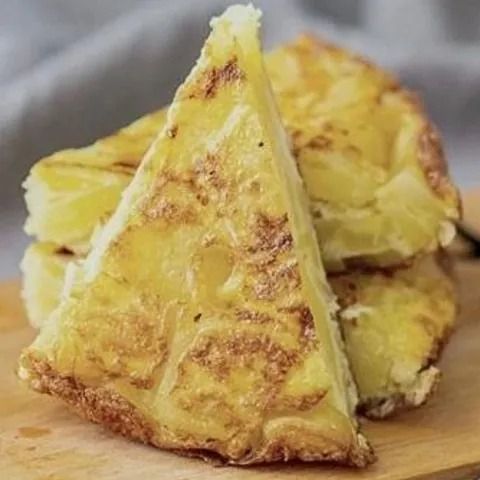Un primer plano de un trozo de comida en una tabla de cortar de madera.
