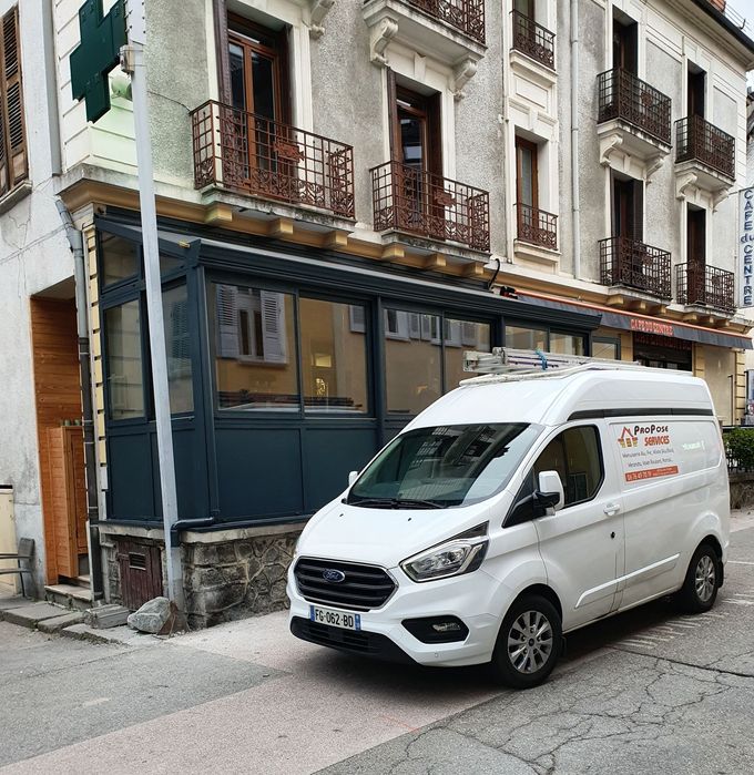 Camion avec logo garé devant une véranda