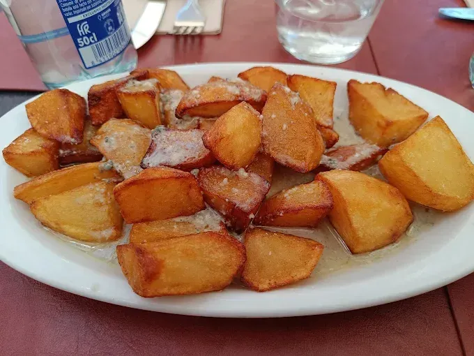 Plato de patatas fritas doradas, ligeramente condimentadas
