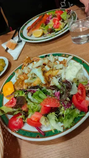 Plato de pescado frito con ensalada y patatas fritas; otro plato con salmón y ensalada.