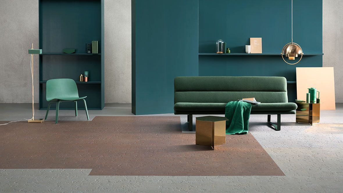 Ein Wohnzimmer mit Couch, Sessel, Lampe und Teppich.