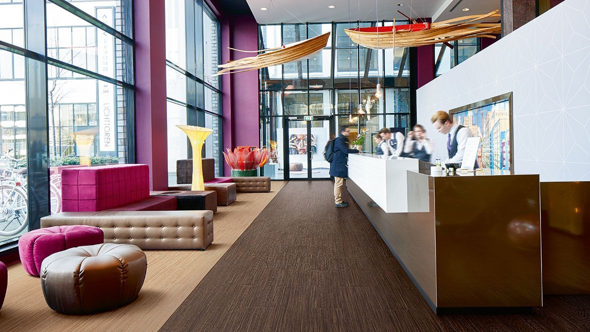 Eine Hotellobby mit einem Mann, der an einer Theke steht.