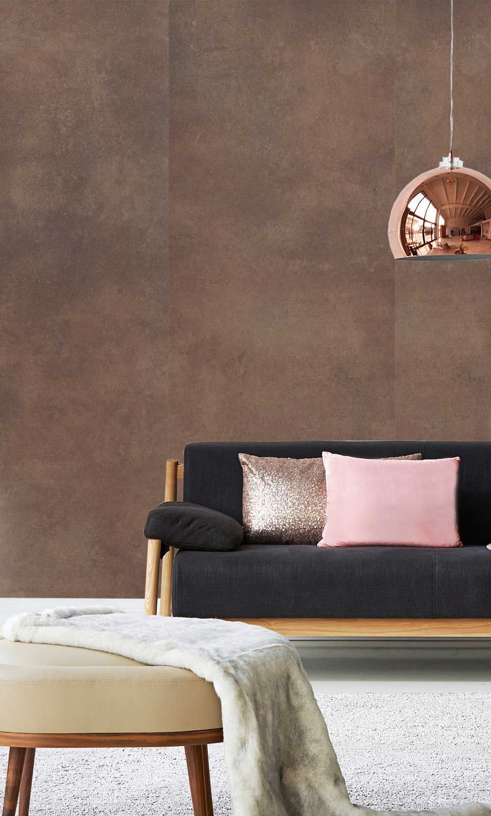 Ein Wohnzimmer mit einer schwarzen Couch und rosa Kissen.