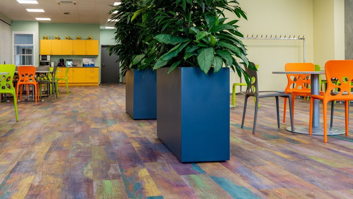 Ein Esszimmer mit Tischen und Stühlen und einem bunten Boden.