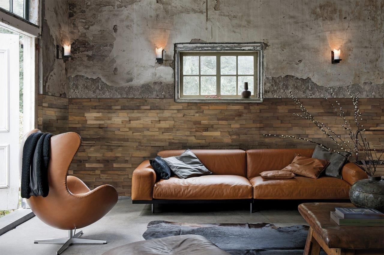 Ein Wohnzimmer mit Couch, Sessel, Tisch und Fenster.