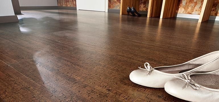 Ein Paar weiße Schuhe steht auf einem Holzboden.