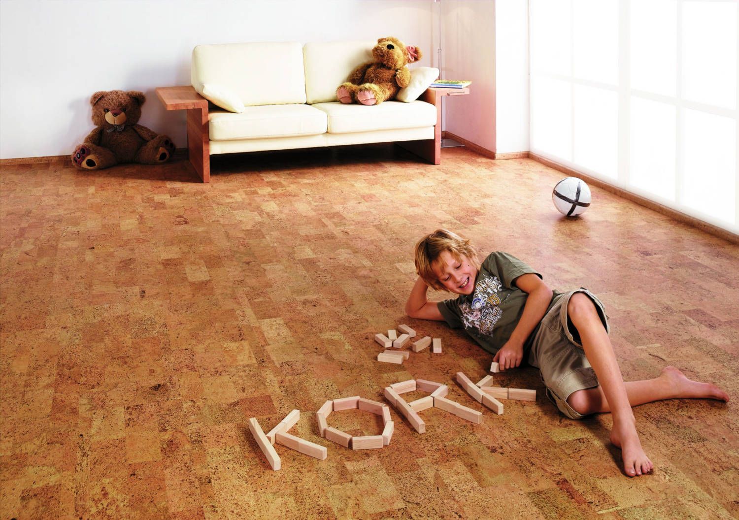 Ein Junge liegt auf einem Korkboden, auf dem das Wort „Kork“ steht