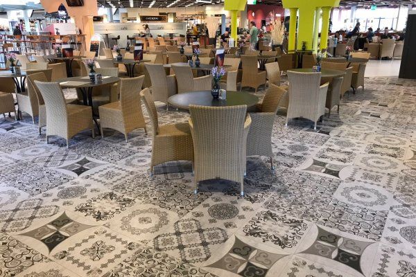 Ein Restaurant mit Tischen und Stühlen und gefliestem Boden.