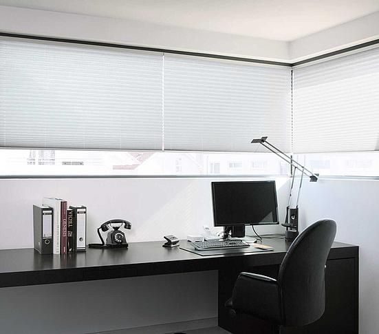 Ein Schreibtisch mit einem Computer und einem Telefon darauf