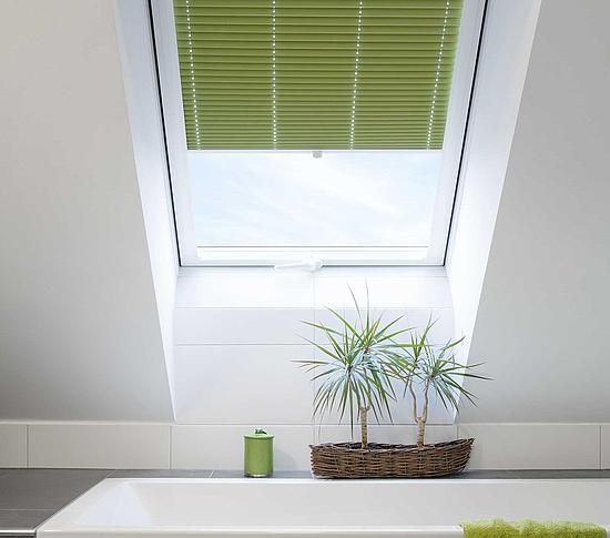 Ein Badezimmer mit Badewanne und einem Fenster mit grünen Jalousien.