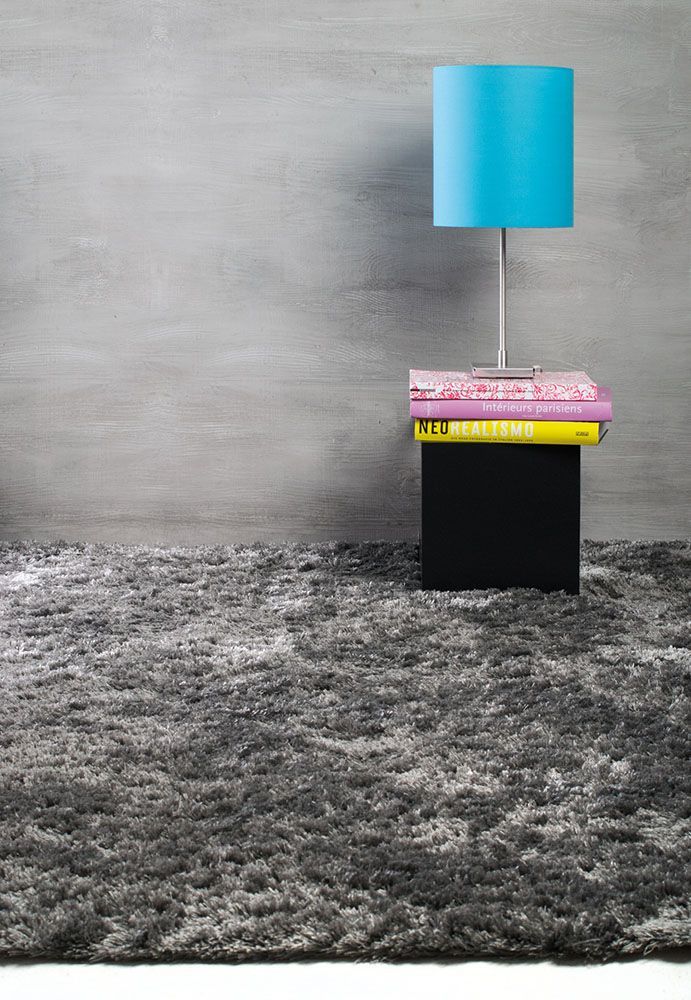 Auf einem Stapel Bücher auf einem Tisch steht eine Lampe.