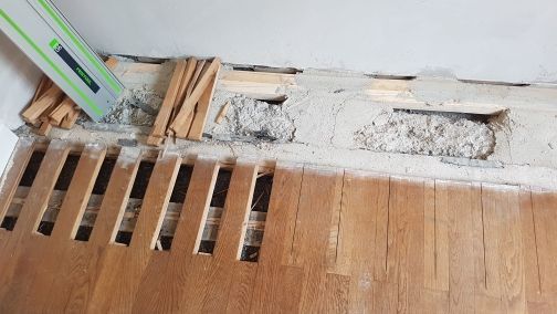 Ein Holzboden mit einem Loch wird repariert.