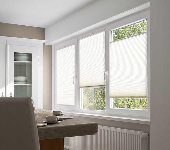 Eine Küche mit Tisch und Stühlen und einem Fenster mit Jalousien.