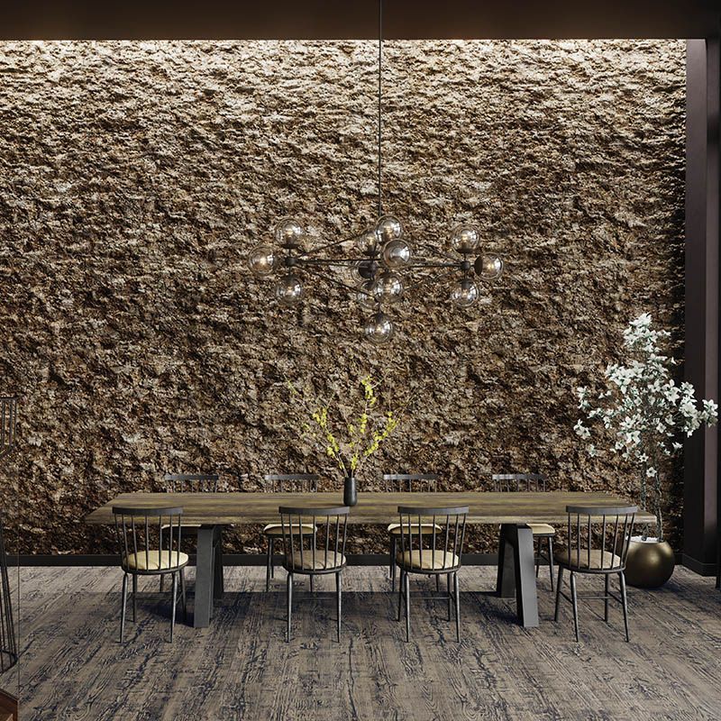 Ein Esszimmer mit einem Tisch und Stühlen vor einer Steinwand.