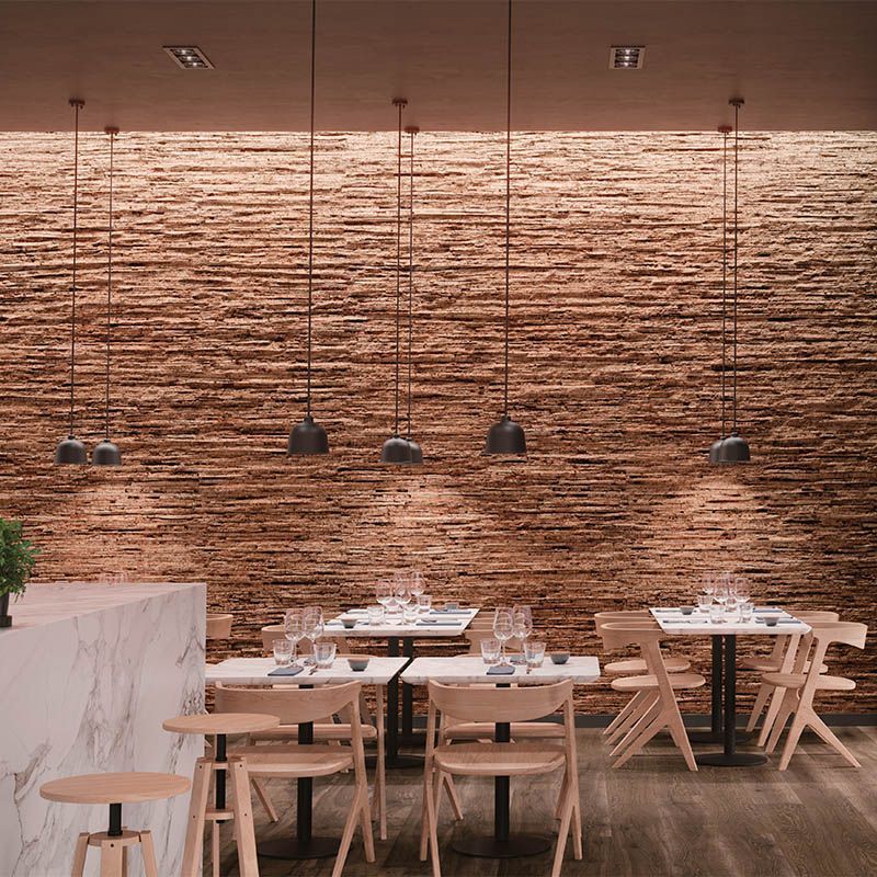 Ein Restaurant mit Tischen und Stühlen und einer Backsteinmauer