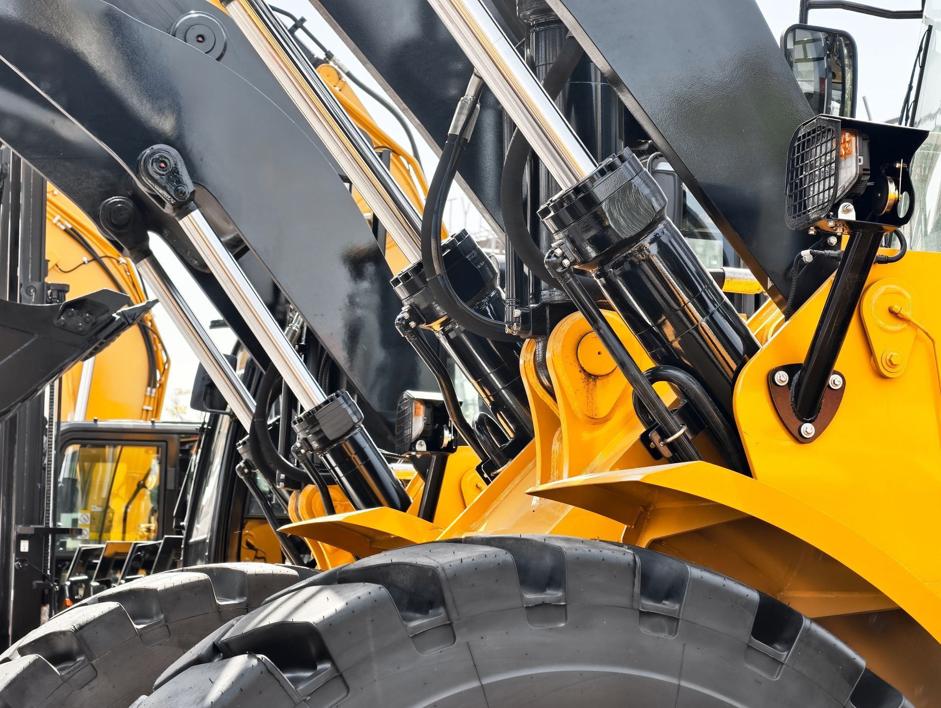 Engin de chantier jaune équipé de bras hydrauliques.