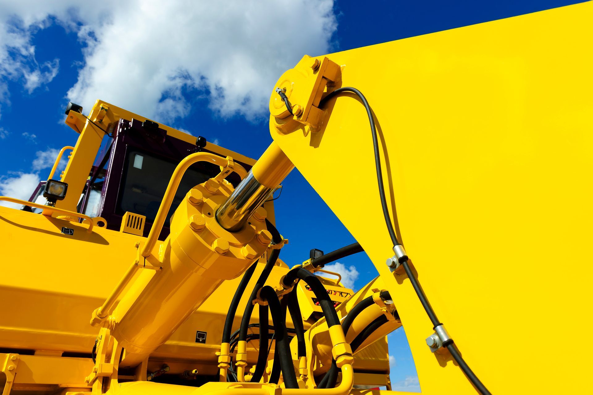 Engins de chantier jaune vif sur fond de ciel bleu nuageux