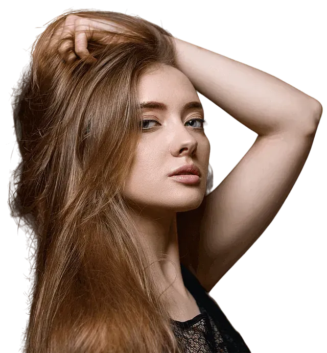 Una mujer con cabello castaño largo sostiene su cabello con su mano.