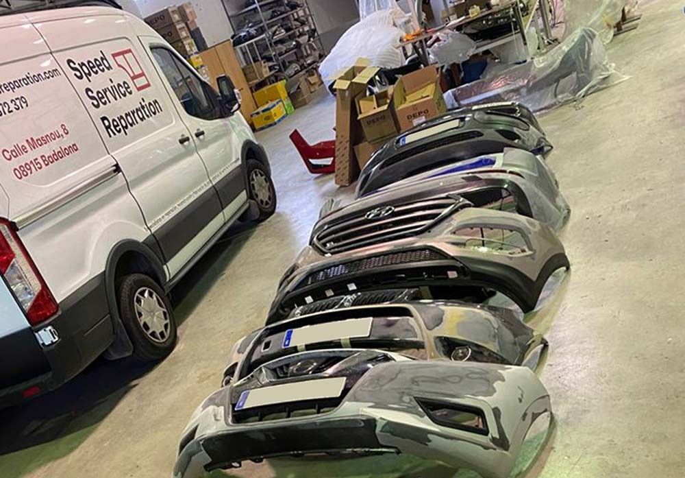 Una furgoneta blanca está aparcada junto a una fila de parachoques en un garaje.