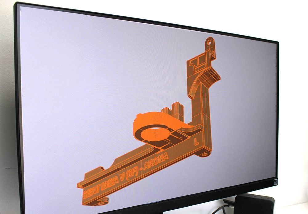 Un monitor de computadora muestra un modelo 3D de un objeto naranja.