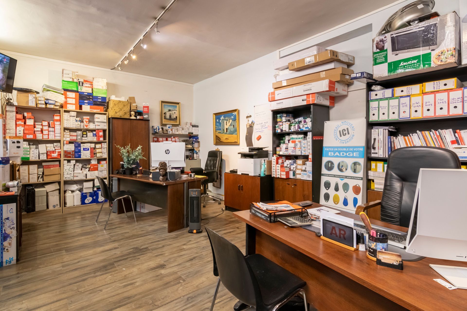 Bureau encombré avec des bureaux, des étagères de boîtes et des fournitures
