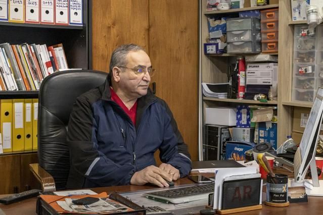 Gérant de l'entreprise S.D.R. assis derrière un bureau en train de regarder un écran d'ordinateur