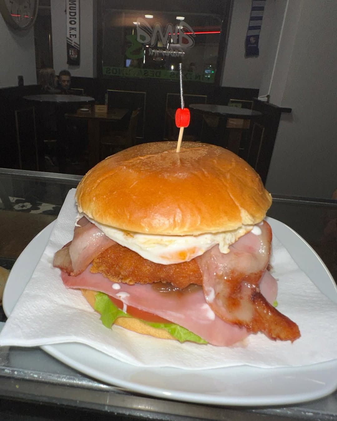 Mini hamburguesas y sándwiches en bandeja blanca, cubiertos con palillos, lechuga y tomate.