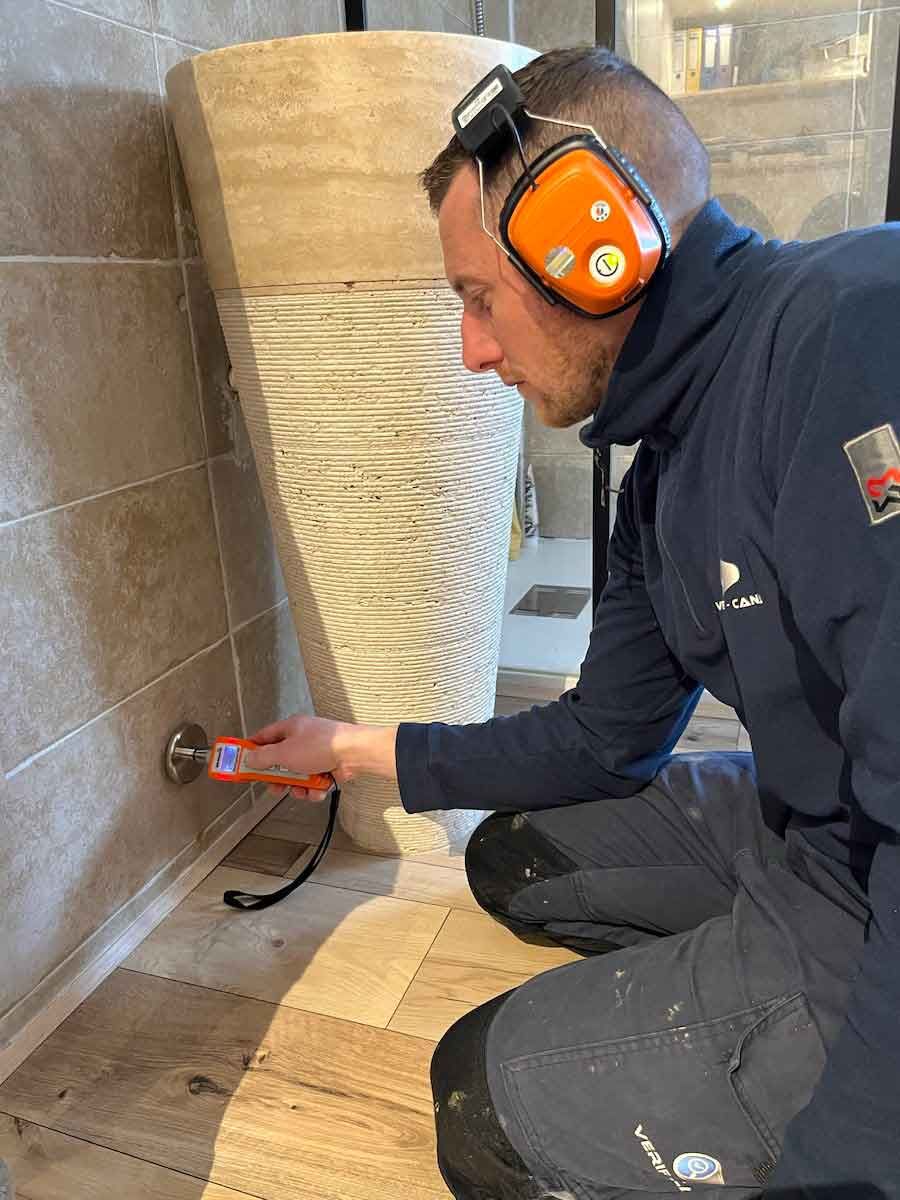 Ouvrier effectuant la recherche de fuite dans une salle de bains