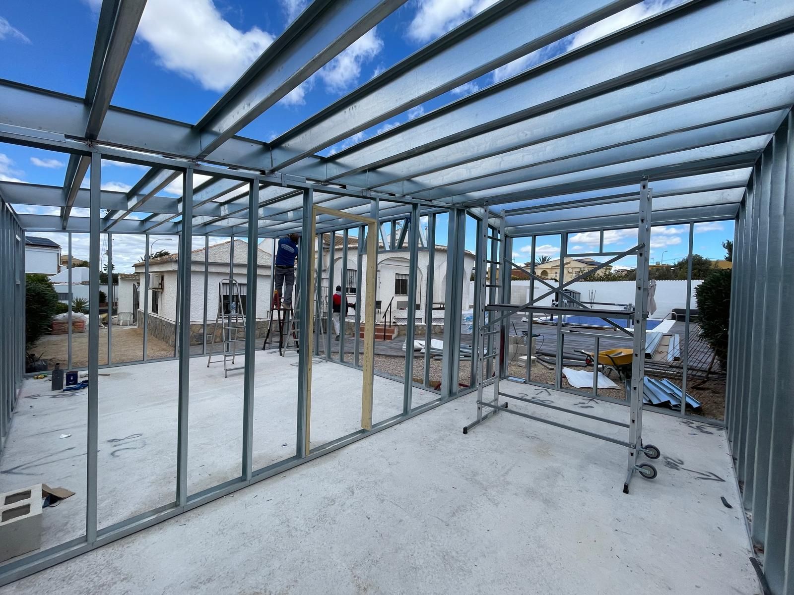 Una habitación en construcción con una estructura de metal y una escalera.