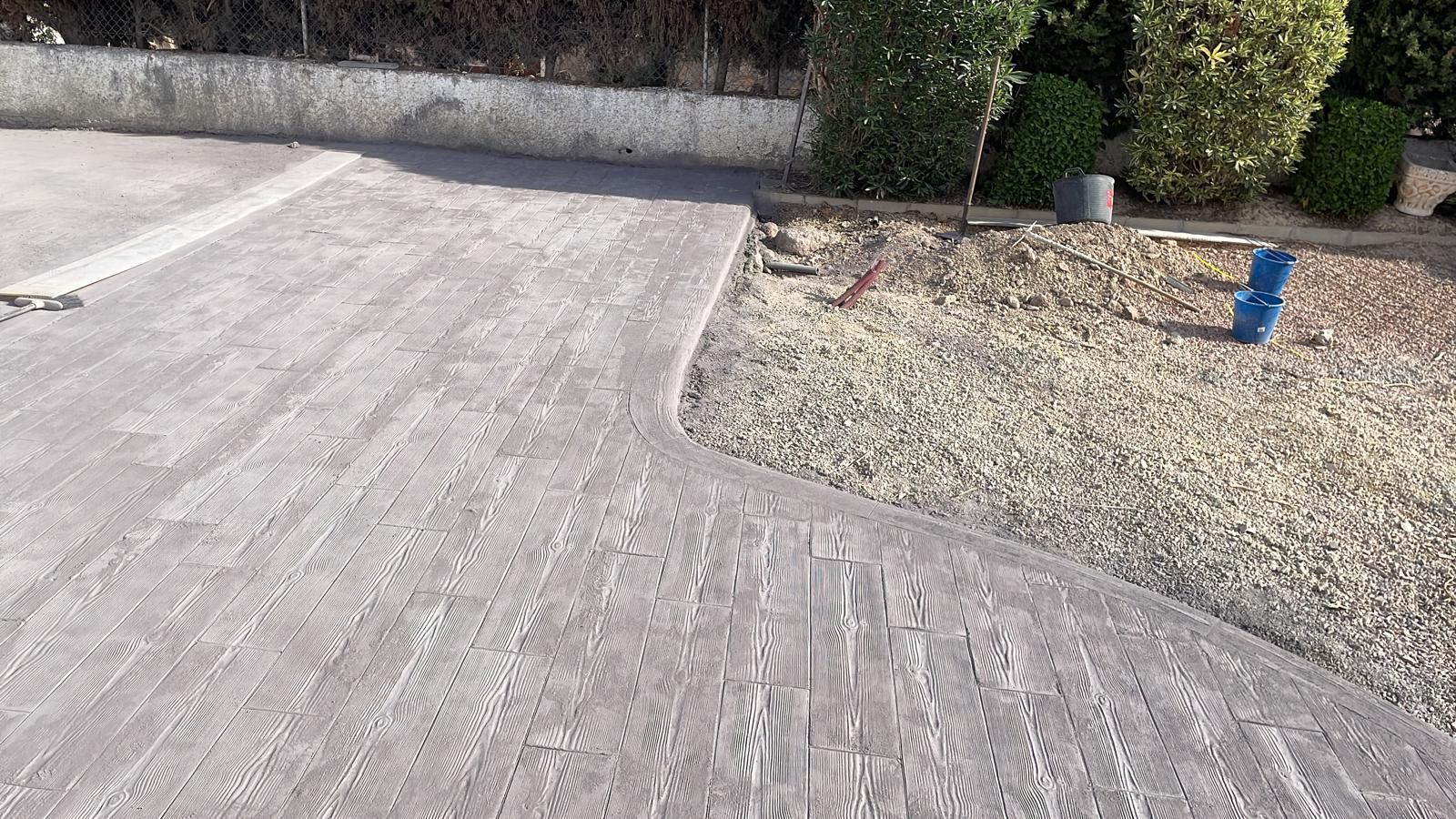 Se está construyendo un camino de entrada de hormigón en un patio trasero.