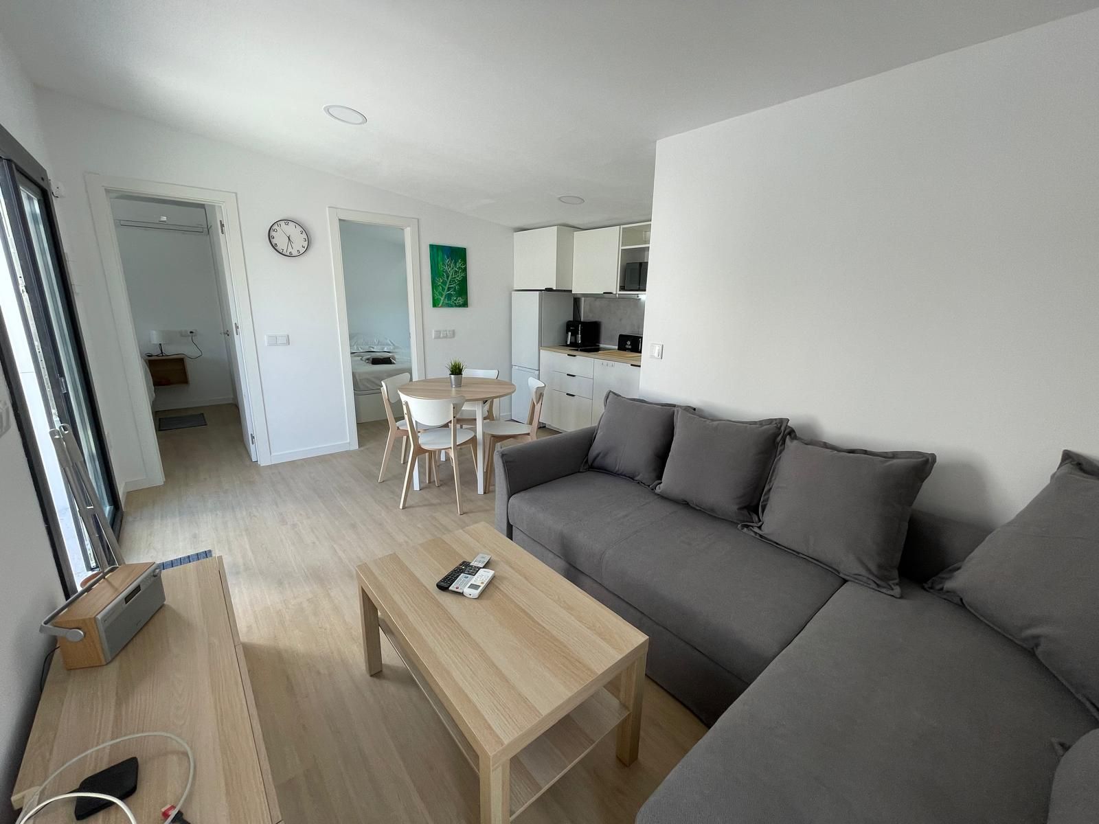 Una sala de estar con sofá, mesa y sillas.