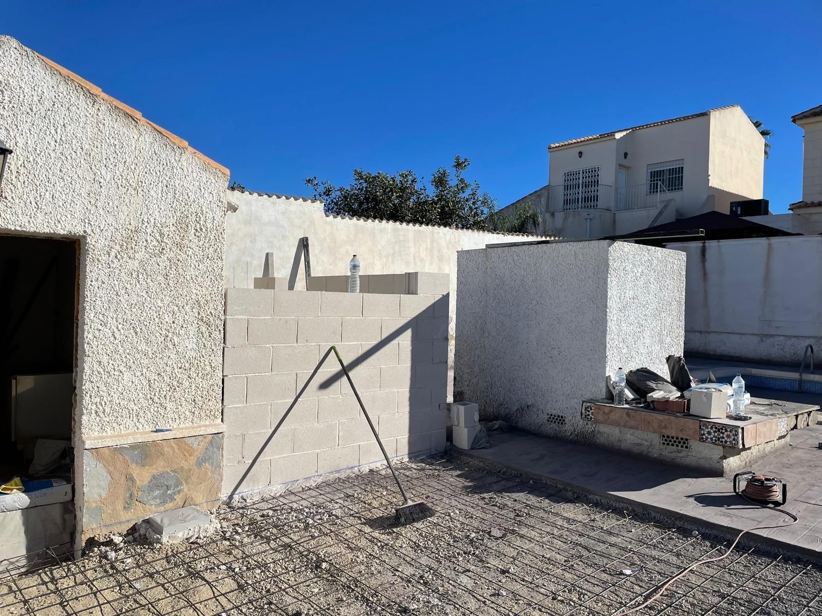 Se está construyendo un muro de ladrillos al lado de una piscina.