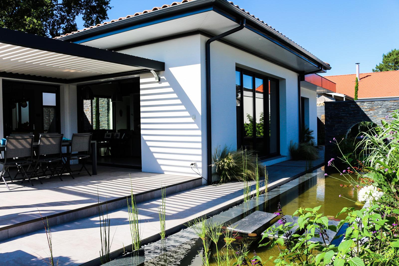 Photo de l'arrière d'une maison à côté d'un bassin extérieur.