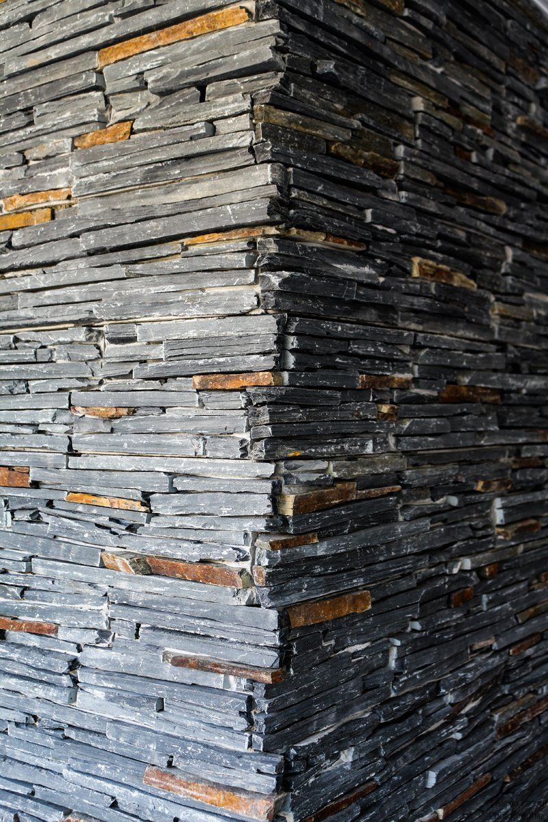 Photo d'un mur en pierres apparentes grise.