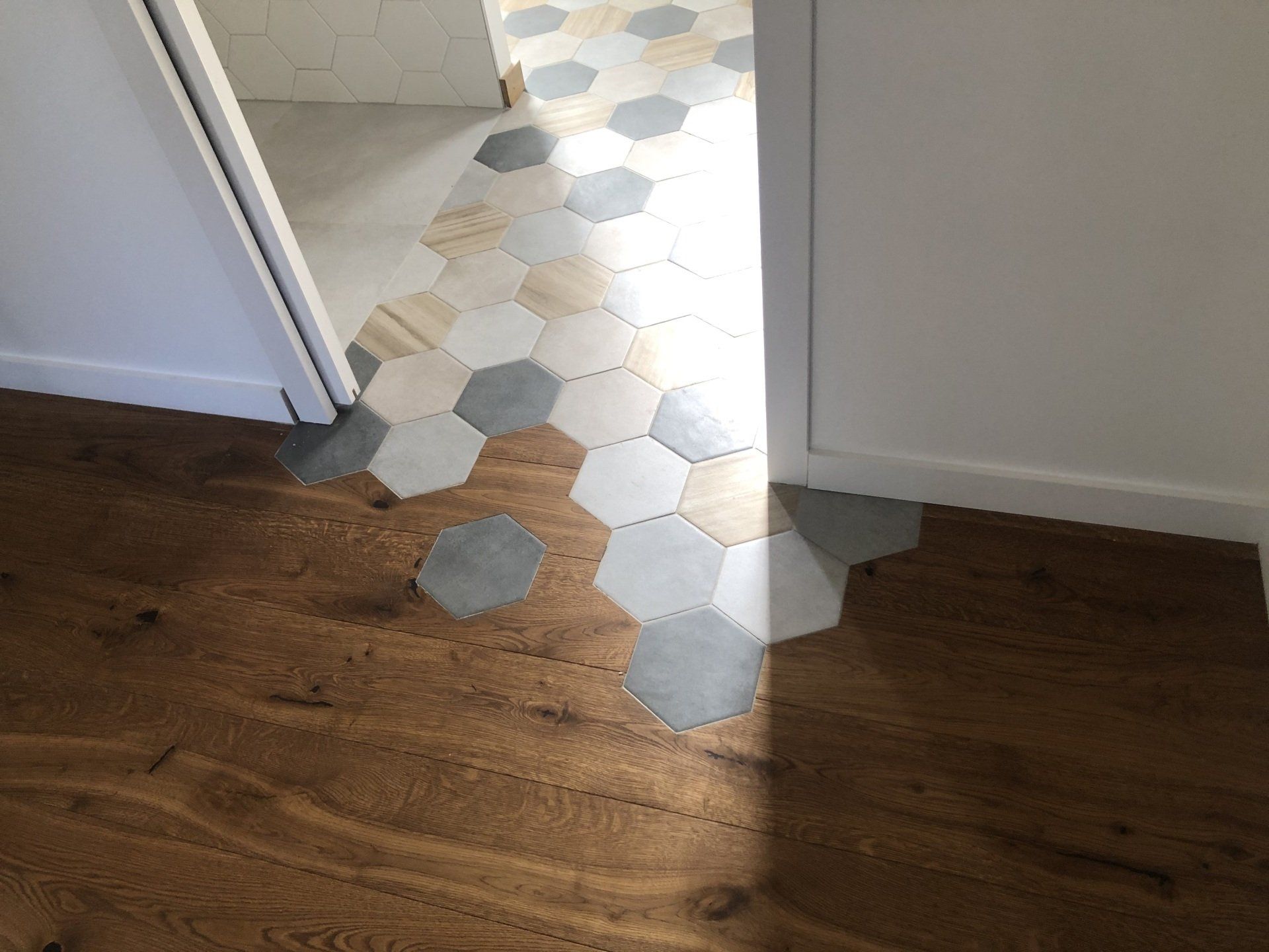 Photo d'un carrelage en mosaic à côté d'un plancher.