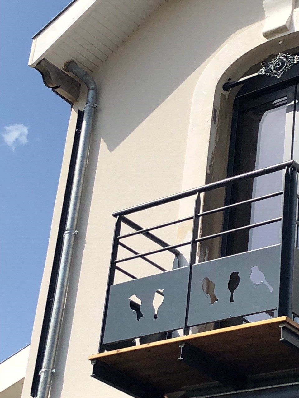 Photo d'un garde-fou gris avec des oiseaux sculptés.