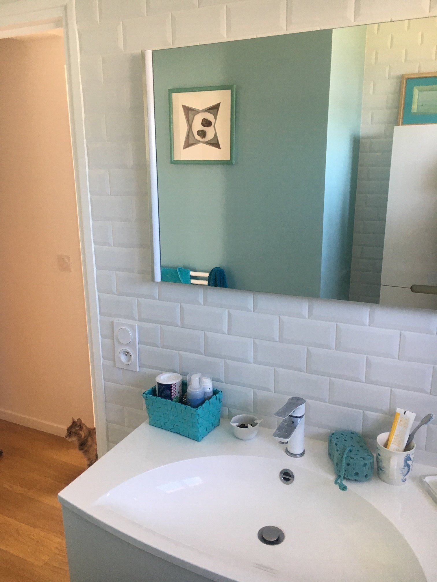 Photo d'un carrelage blanc au-dessus d'une vasque de salle de bains.