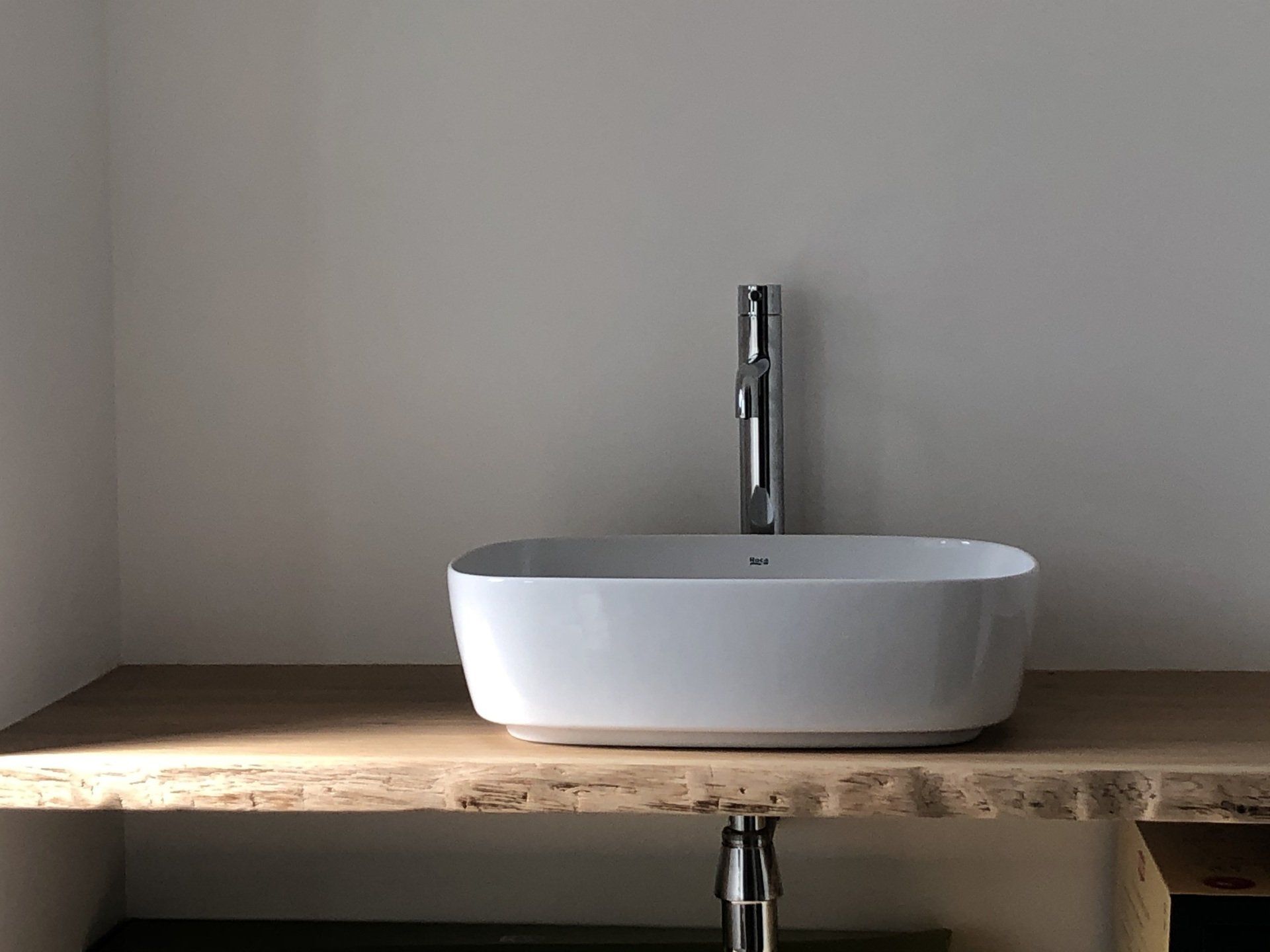 Photo d'une vasque posée sur un plan de travail en bois.